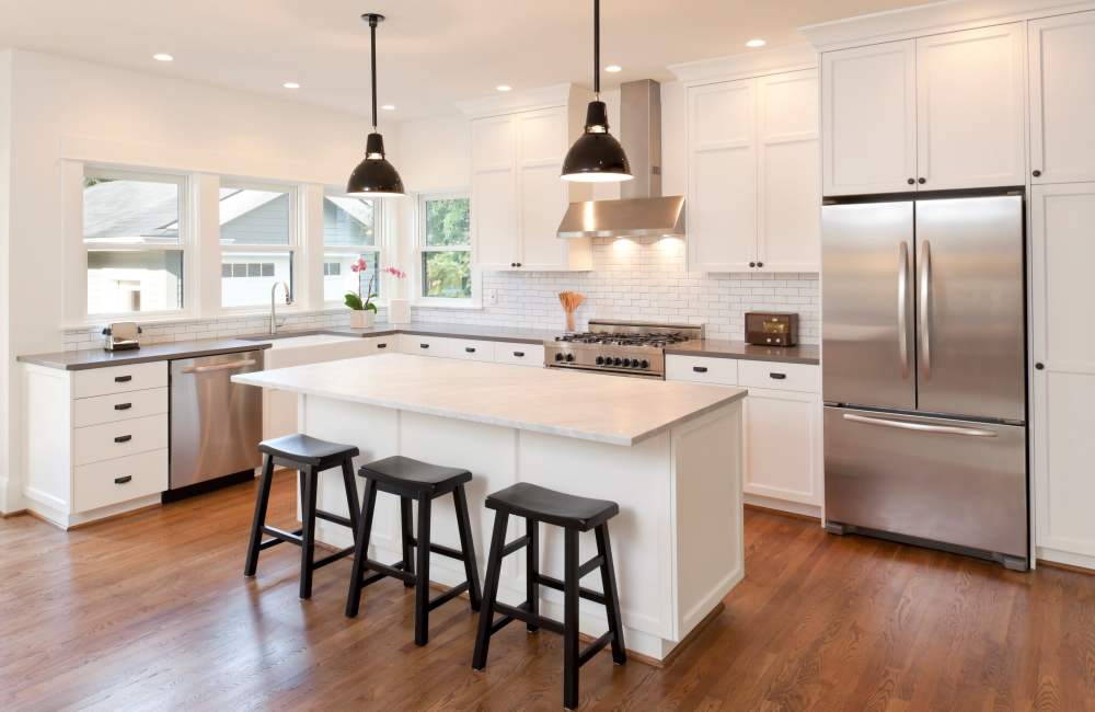 Charming kitchen wite granite countertop, refrigerator and a chimney  at Whispering Woods in Modesto, California