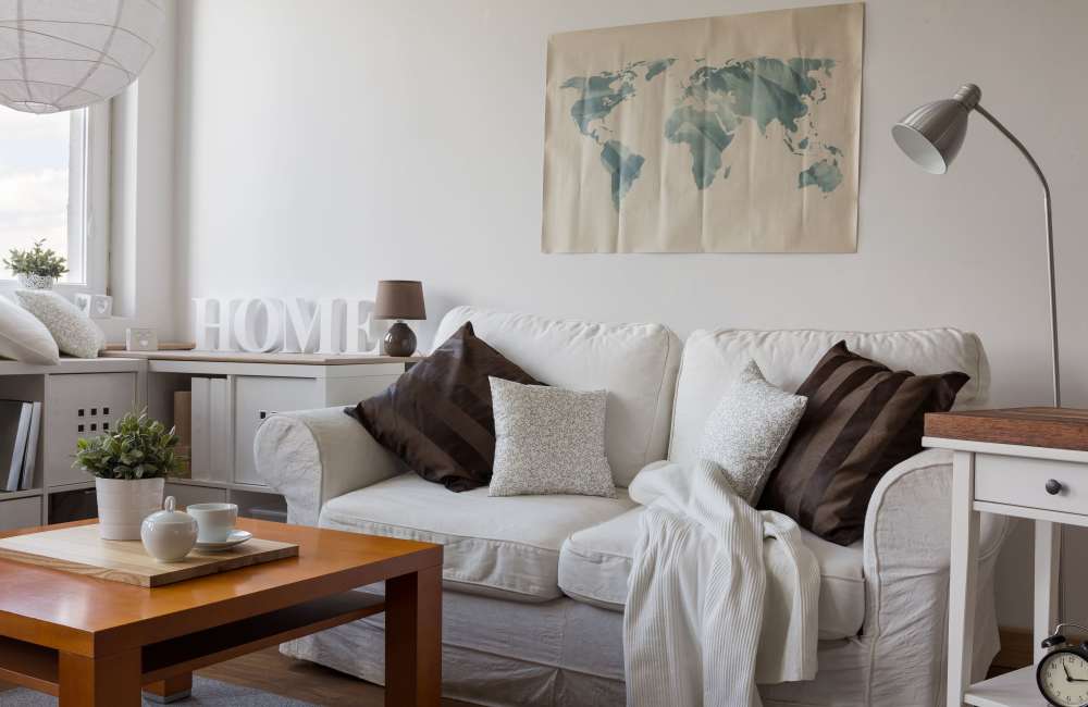 Cozy living room with comfortable couch, storage cabinets and vinyl flooring at Douglas Park in Compton, California