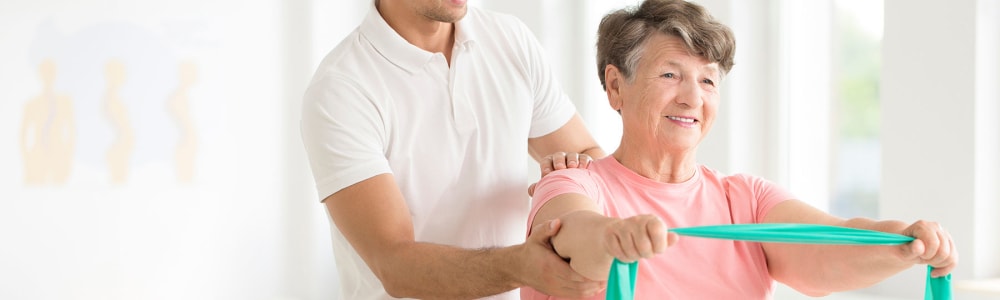 Resident and a therapist using a theraband at Transitions At Home - Central in Stevens Point, Wisconsin