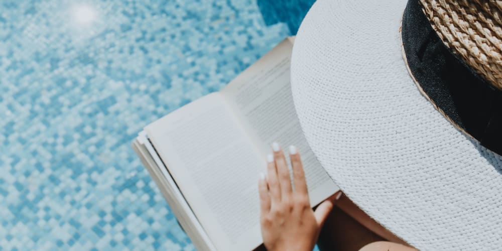 Resident reading by the pool at Encore at Deerhill in Clarkston, Michigan