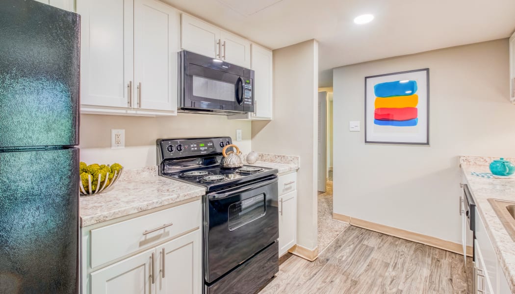 Modern kitchen with white cabinets in a model home at Preserve at Cradlerock Apartment Homes in Columbia, Maryland