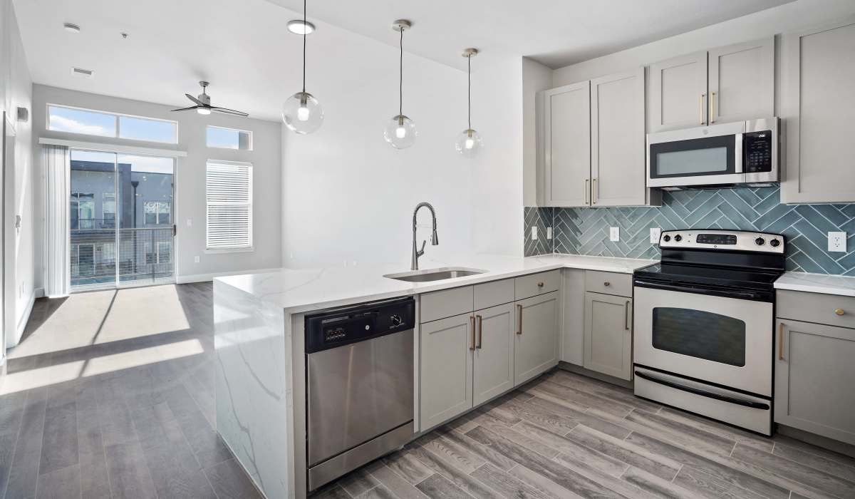 Modern kitchen with stainless-steel appliances and wood cabinets at Archer Medical District in Dallas, Texas
