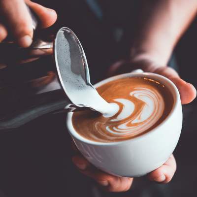 Resident mixing milk in coffee cup at  LeSilve in Middleton, Wisconsin