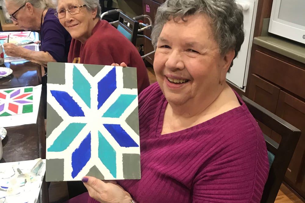 Resident holding up a piece of art at Edencrest at The Legacy in Norwalk, Iowa