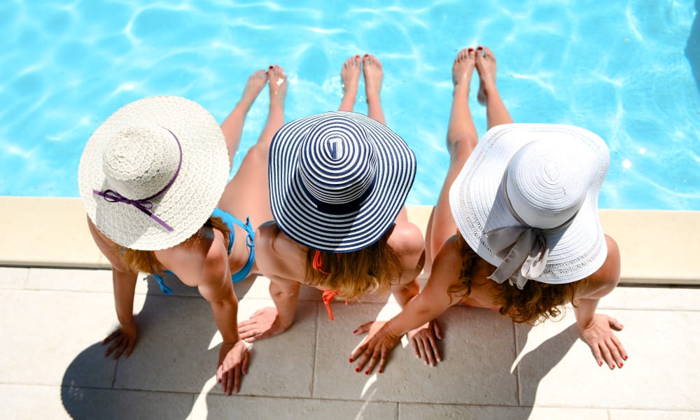 Three ladies with sun hats by the pool at Seventeen15