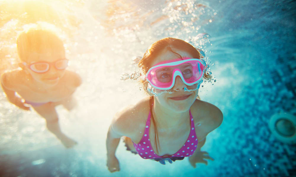 Kids exploring the pool with goggles on at Bonterra Apartments in Fort Wayne, Indiana