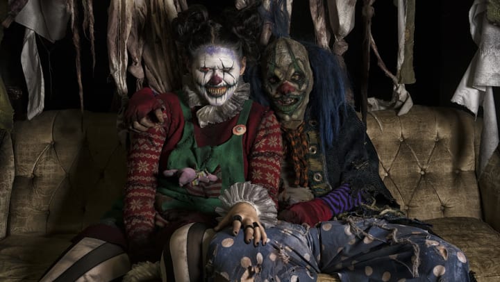 Two very scary clowns sitting on a rugged couch at Reindeer Manor near Olympus at Ross
