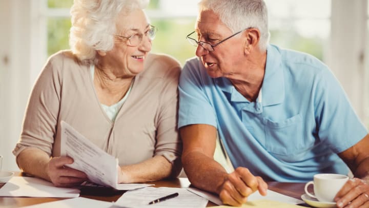 Senior adult couple using calculator to consider price options