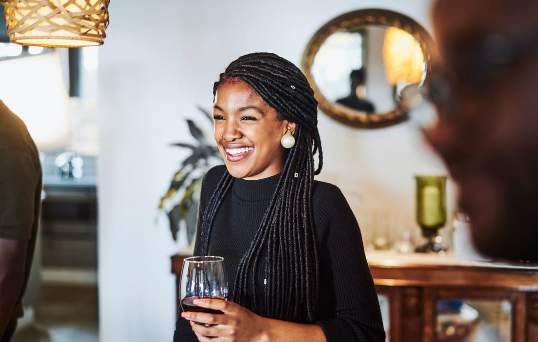 Woman smiling while drinking wine at The Collection Townhomes in Dallas, Texas