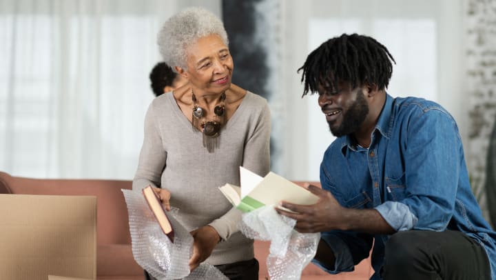 Senior woman unpacking boxes with adult son