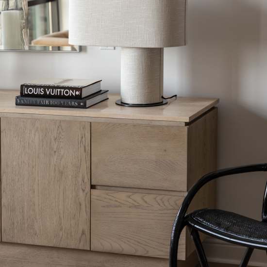 Light wood cabinet with two drawers and lamp at Novel Turtle Creek in Dallas, Texas