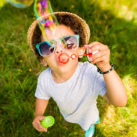 A child blowing bubbles in the grass at Riverstone in Macon, Georgia