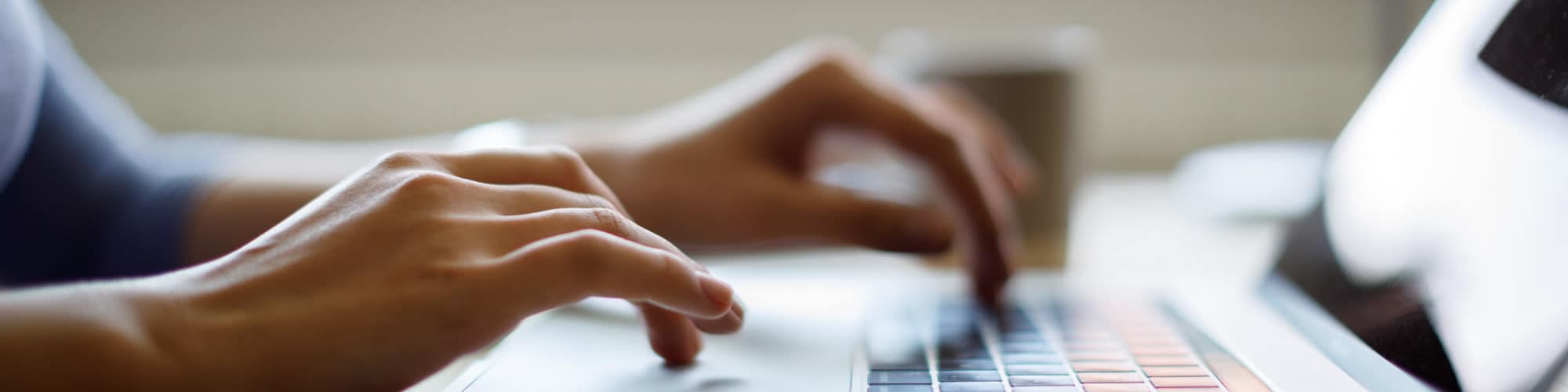 Contact Us | A shot of hands typing on a keyboard laptop at Del Coronado in Alameda, California
