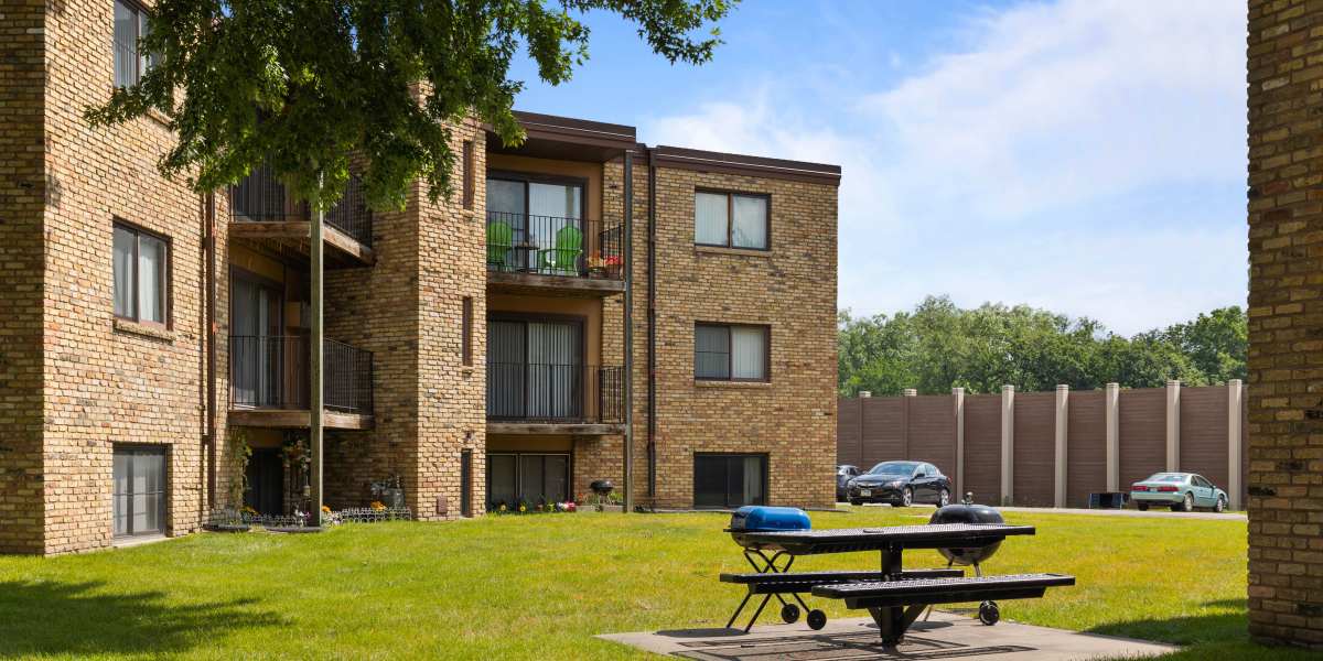 Apartment building exterior with lawn and parking lots at Fountain Terrace in New Brighton, Minnesota