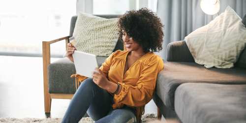 Woman making her online payment in a comfy living room at Kernwood Terrace in Los Angeles, California