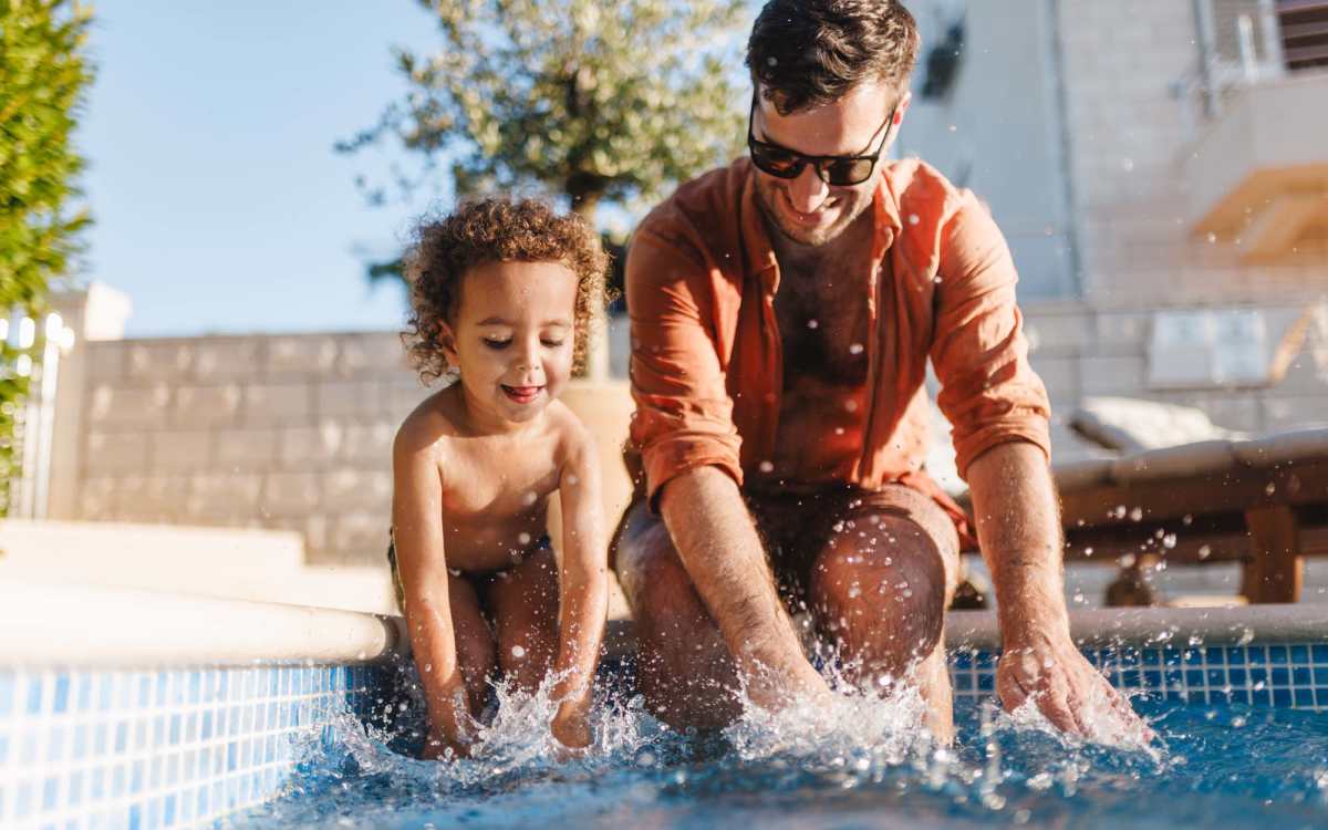 Resident with his son in a swimming pool at Fulton Hill Apartments in Tallahassee, Florida