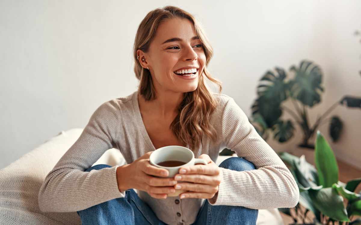 Woman relaxing with a cup of coffee in a cozy living space at Fairfield Commons in Stamford, Connecticut 