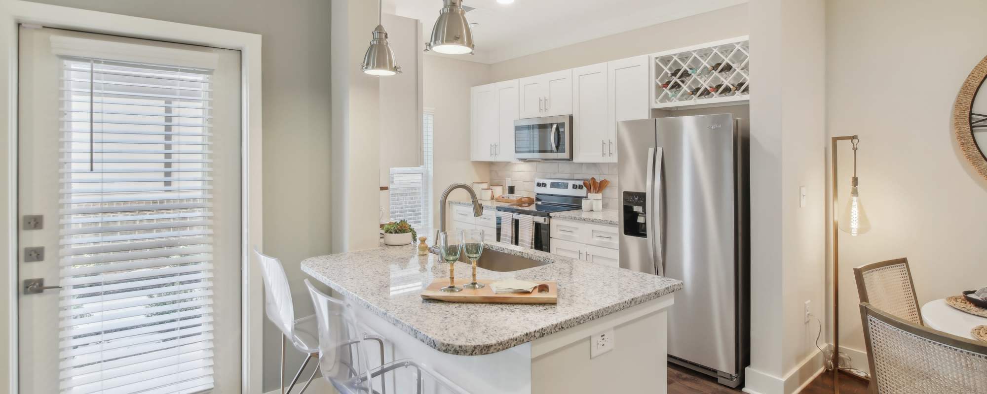 Model kitchen with white cabinetry, custom backsplash, and stainless-steel appliances at Somerset in McDonough, Georgia
