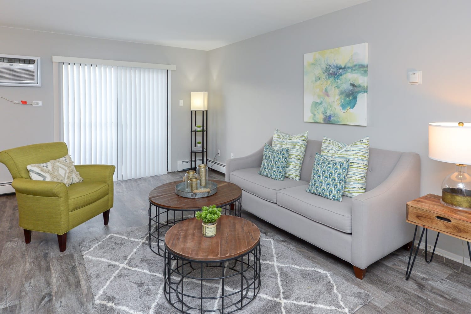 Living room with plank flooring and private patio at Imperial Gardens Apartment Homes in Middletown, NY