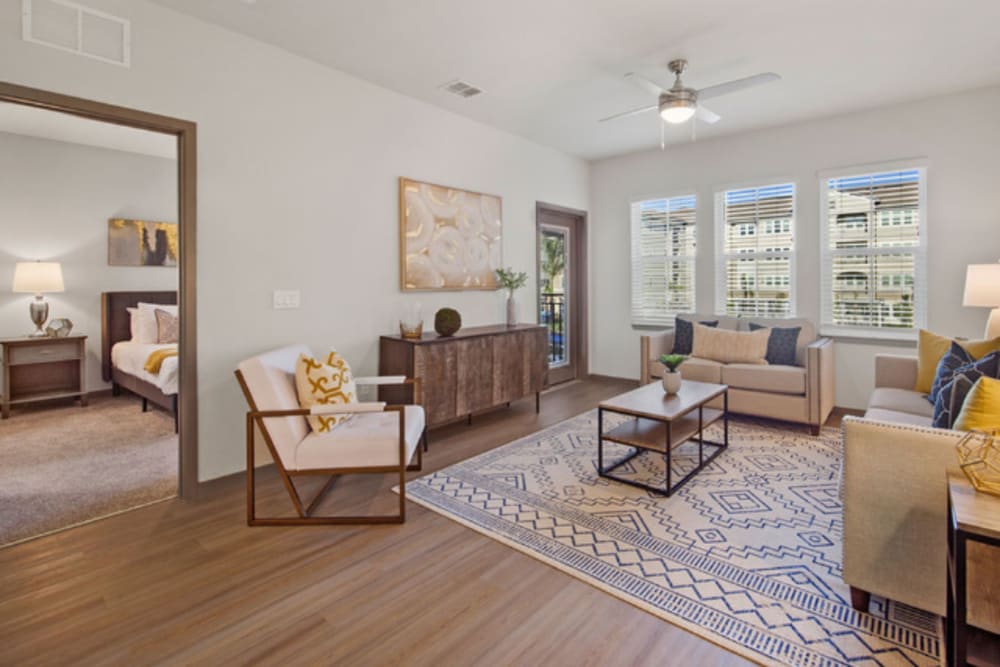 Bright and spacious living room with hardwood style flooring at Murano at Three Oaks in Fort Myers, Florida