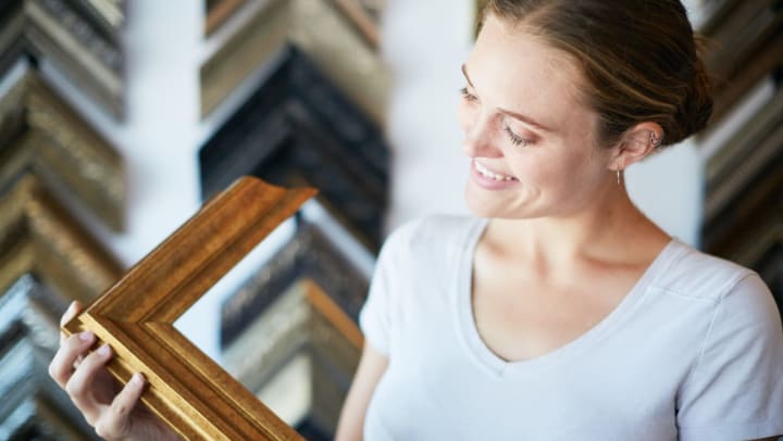 Woman smiling while examining a sample at a picture framing shop