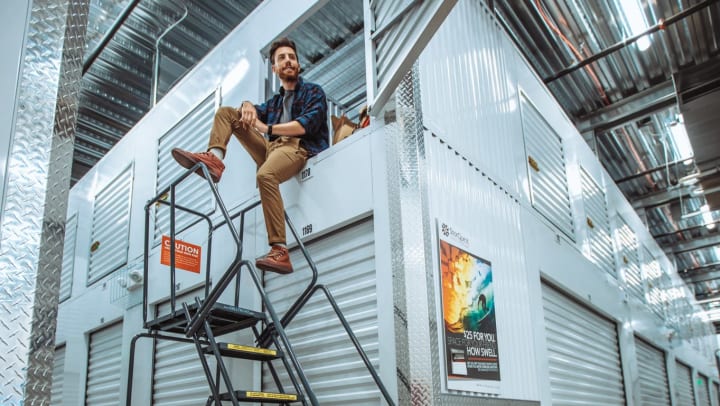 A man sitting on some stairs at a storage unit