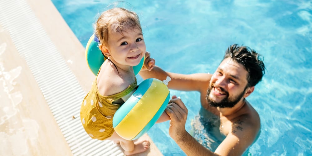 A father helping his child into the swimming pool at Nine Two Six West in Augusta, Georgia