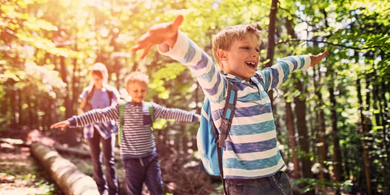 Children with backpacks walking through trees near San Onofre III in San Clemente, California