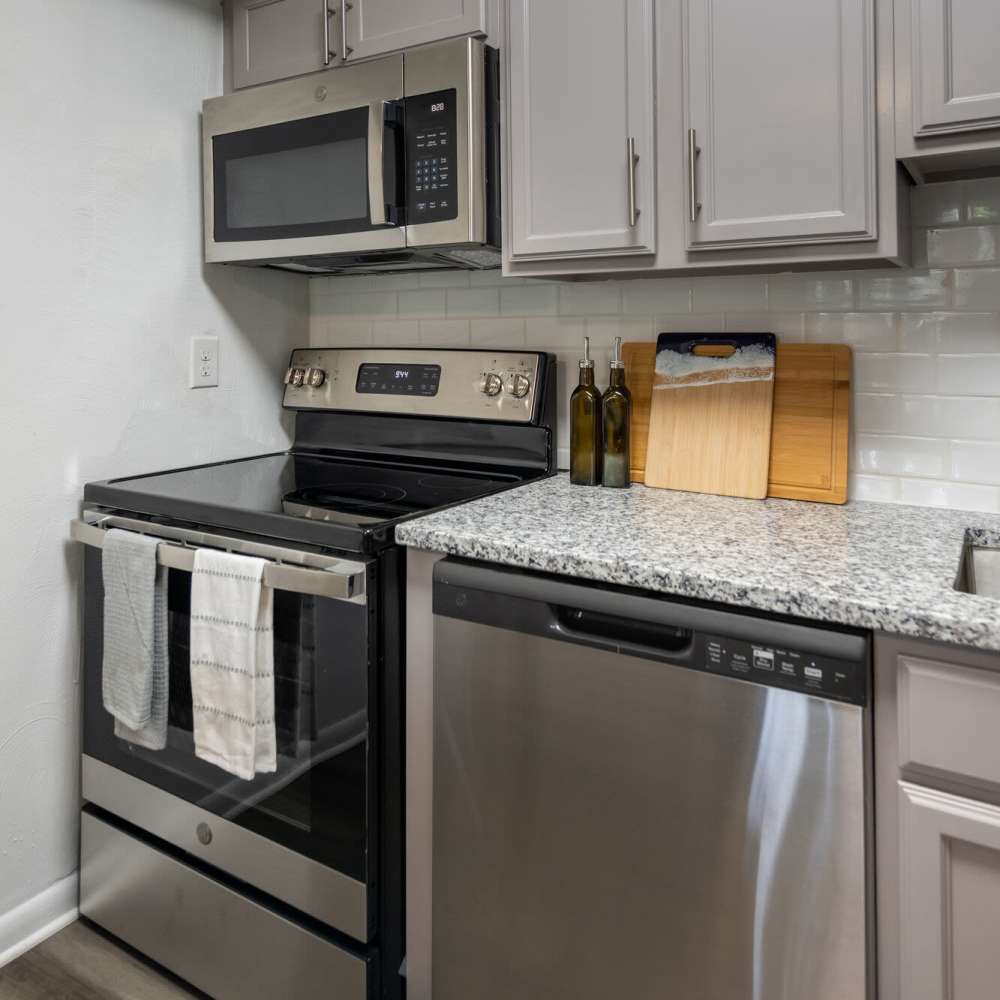 Kitchen with range, refrigerator and stainless-steel dishwasher at Woodmere Trace in Norfolk, Virginia