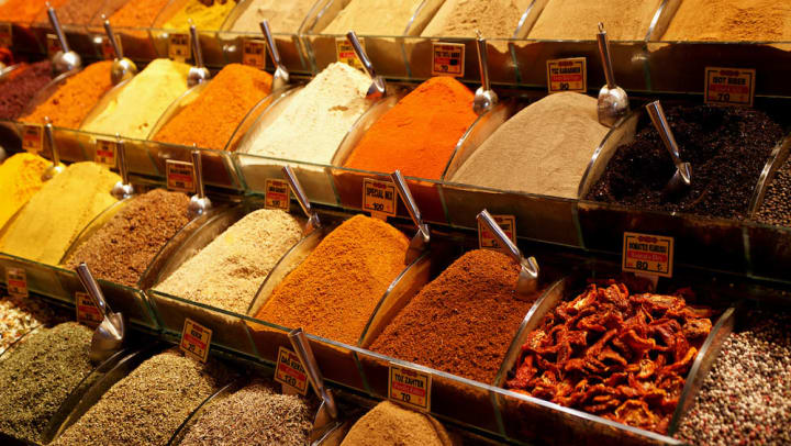 Bulk containers of different spices displayed in a spice shop