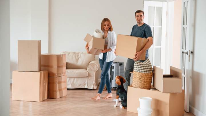 Couple moving into a new apartment surrounded by boxes full of apartment essentials