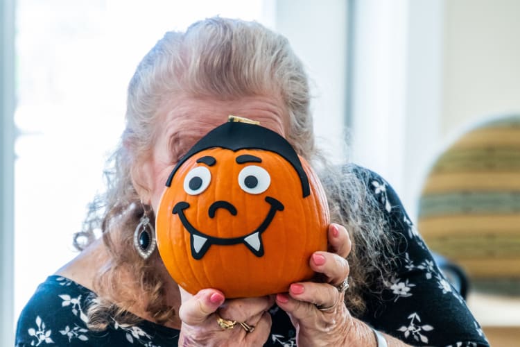A resident poses with a pumpkin craft at Harmony at West Ashley in Charleston, South Carolina