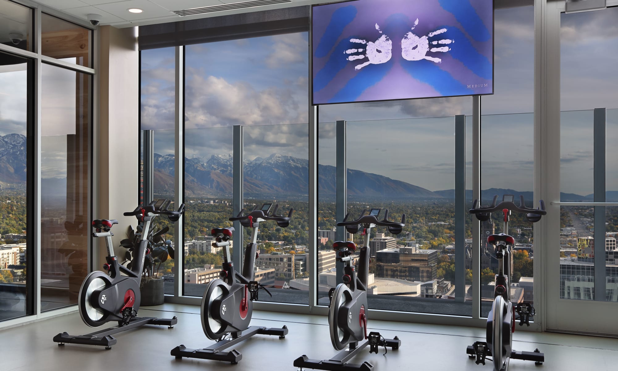 Workout studio with spin bikes and television with windows overlooking the mountains at Luxury high-rise community of Liberty SKY in Salt Lake City, Utah