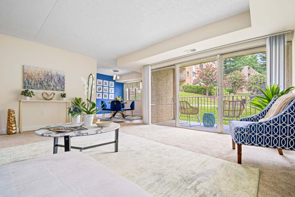 Spacious bedroom with a coffee table, armchairs and a sliding door leading to the private balcony at Windsor Court and Tower in Silver Spring, Maryland