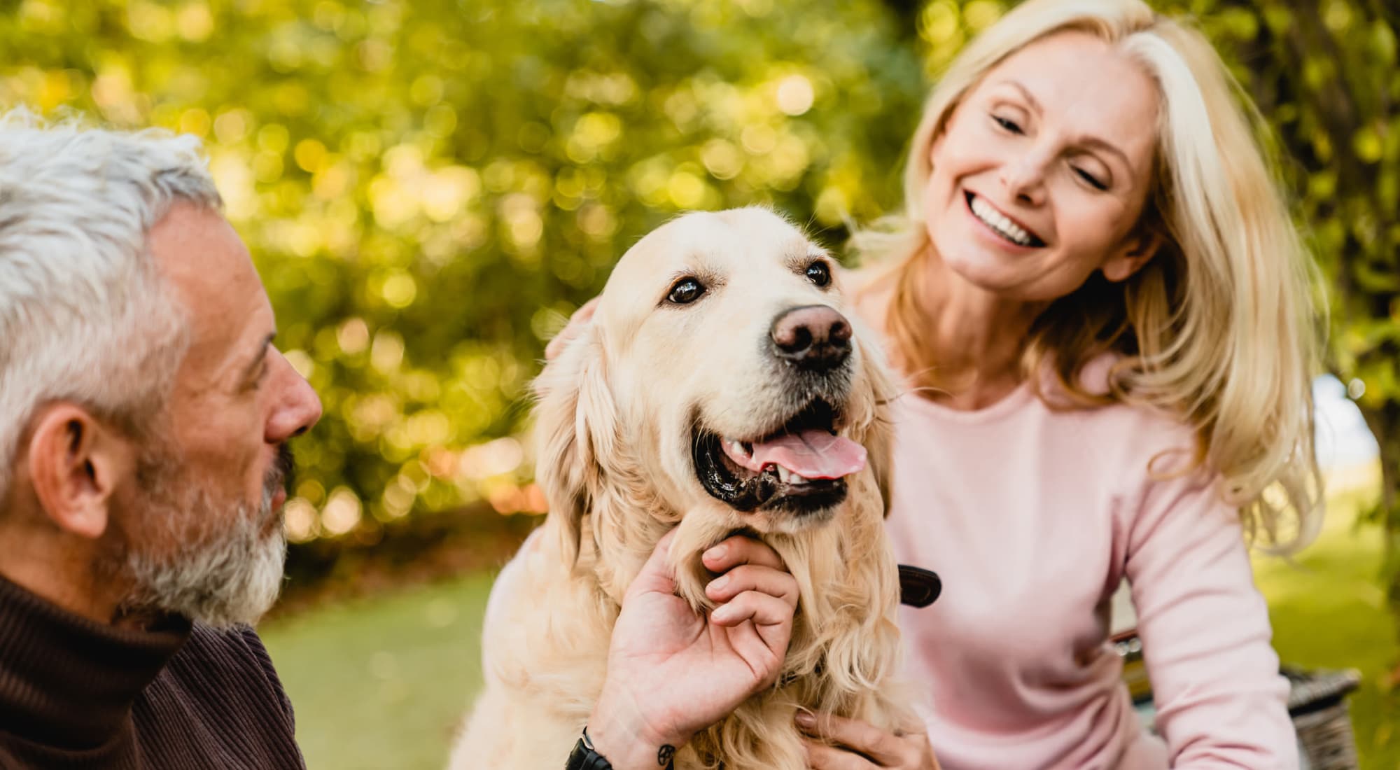 Residents at a park with their golden retriever near Estoria Cooperative Lakeville in Lakeville, Minnesota