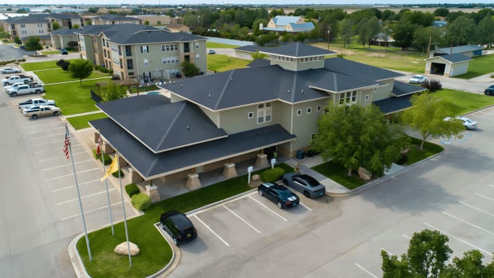 Drone photo of the Windscape Apartment Homes front office in Hobbs, New Mexico. You can see the apartment buildings in the background and cars parked out front.