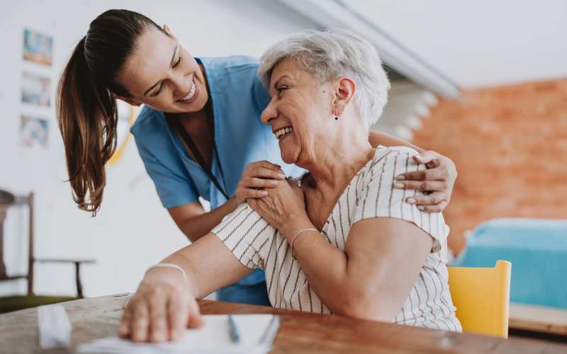 Resident holding hands with caregiver at Tuscan Gardens of Venetia Bay in Venice, Florida