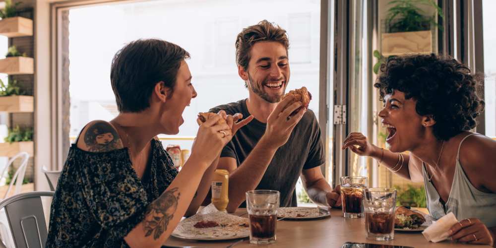 Resident friends eating a meal together near Evergreen Westside in Gainesville, Florida