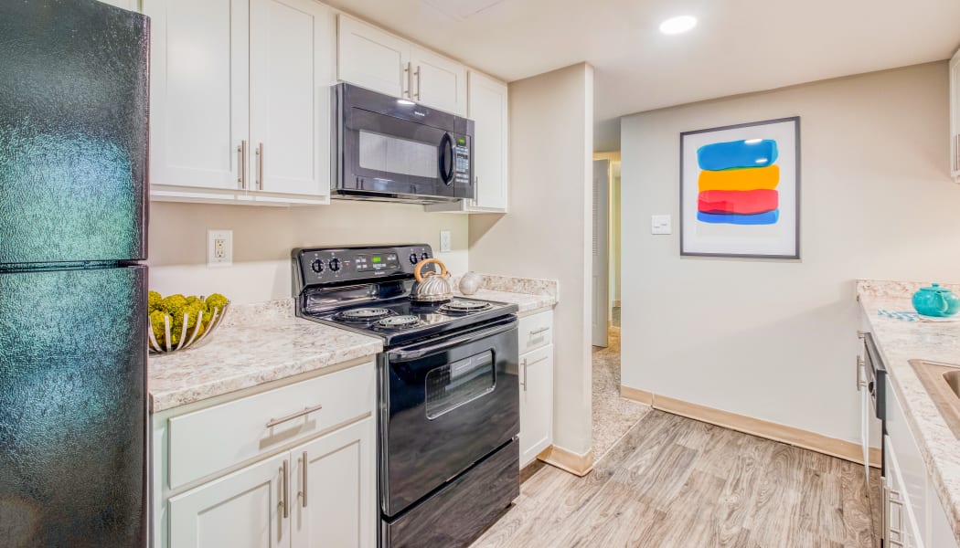 Modern kitchen with white cabinets in a model home at Preserve at Cradlerock Apartment Homes in Columbia, Maryland