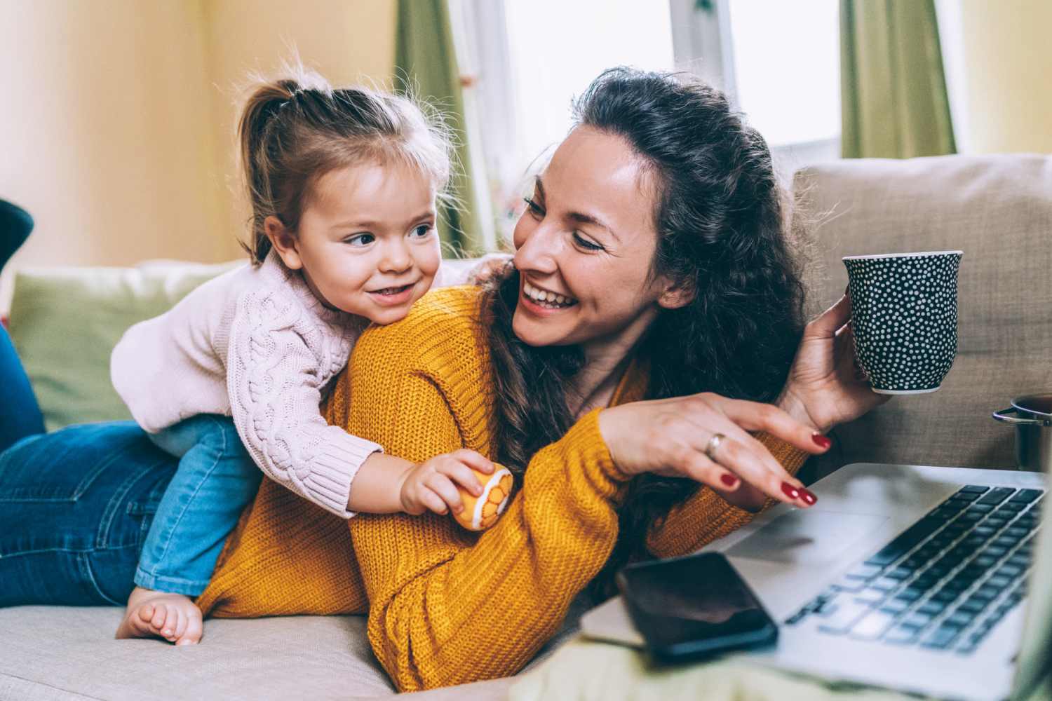 Resident relaxing on a couch with her daughter at Bana At Tujunga in Tujunga, California