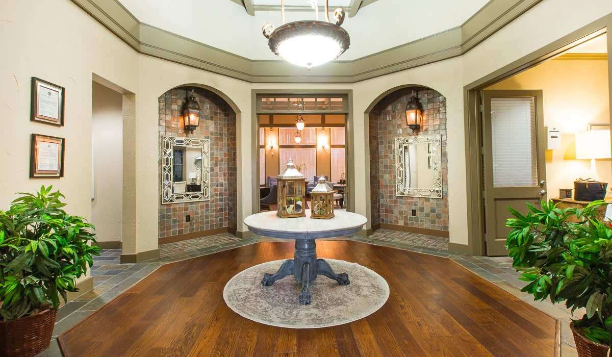 Community lobby area with hard wood flooring and chandelier at Cobblestone Park in Manvel, Texas