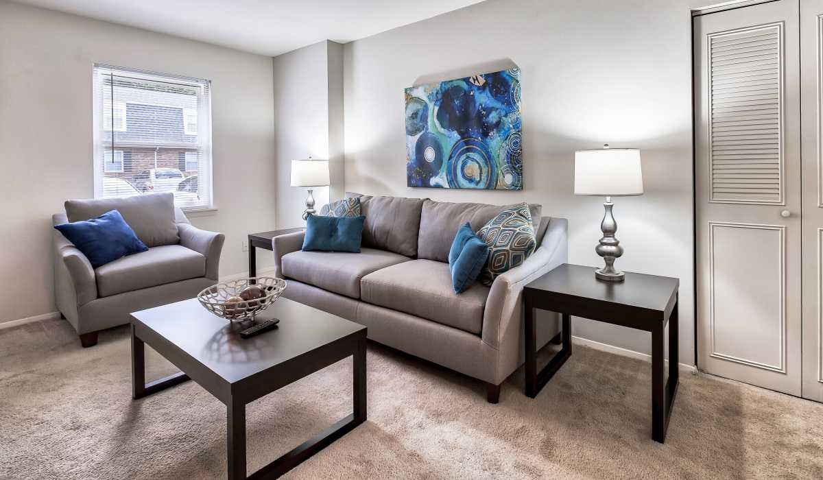 Living room with couch and chair at Misty Pines Apartments in Ashland, Virginia