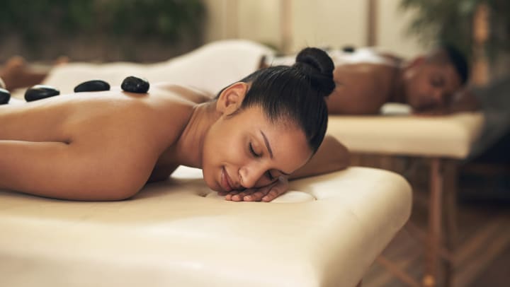 a woman on a massage table with hot stones on her back | Spas in Chandler