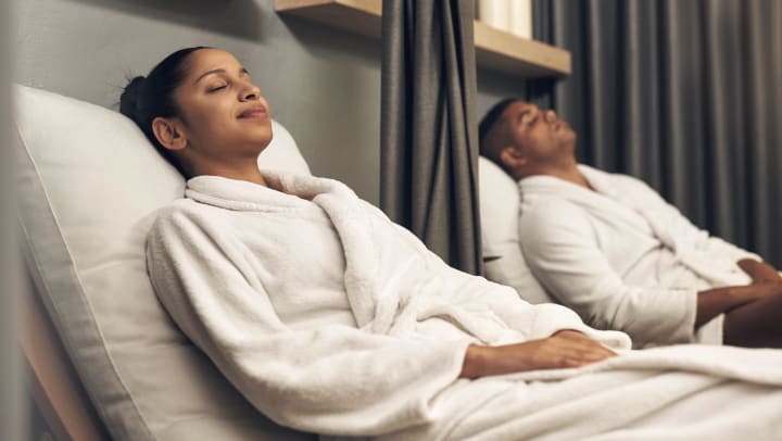 A couple laying down in robes while relaxing at a spa in Durango.