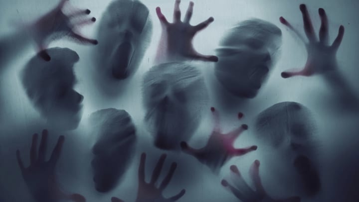 Scary ghost people reached out through a sheer sheet at a haunted house near Olympus Boulevard