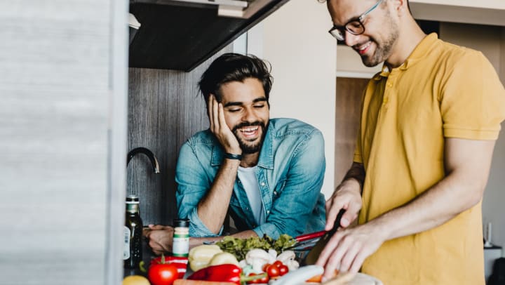 Couple in kitchen chopping vegetables together