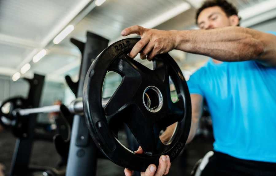 Resident lifting weights in the gym at Standard at Royal Lane in Dallas, Texas