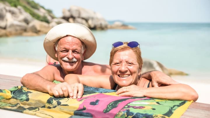 Two seniors sitting on the beach