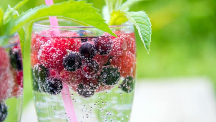 Image of seltzer water beverage with berries and mint.