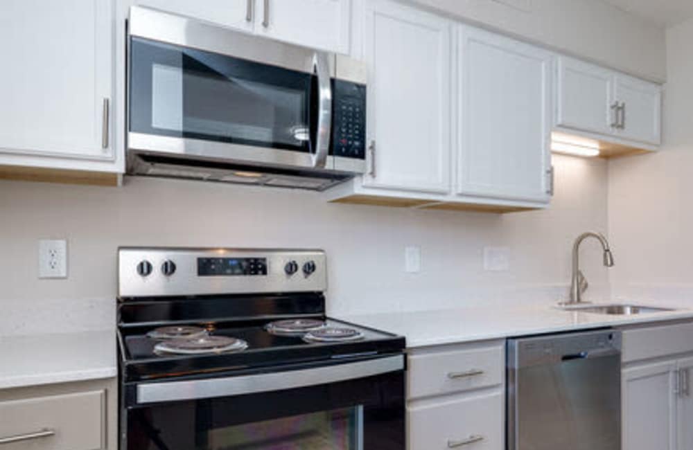 Kitchen with black appliances and wood flooring at Maple Oaks in Middletown, Ohio